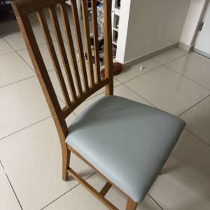 כיסא עץ עם ריפוד אפור על רצפה מרוצפת