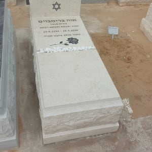 מצבה עם כיתוב בעברית ועיטור פרח