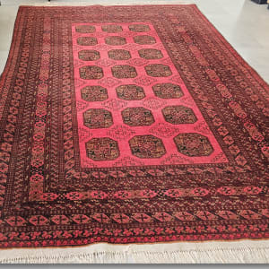 שטיח אדום עם דוגמאות גיאומטריות על רצפה אפורה