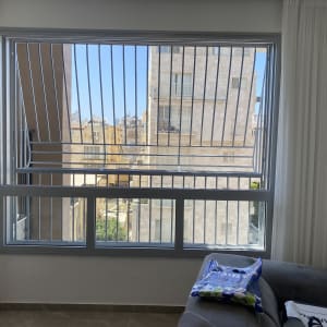 חלון עם סורגים ודירה ברקע