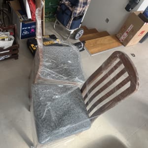 כיסאות עטופים בניילון ליד עגלת קניות וארגזים