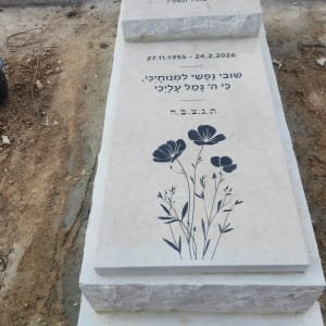 מצבה עם כיתוב בעברית ועיטור פרחים