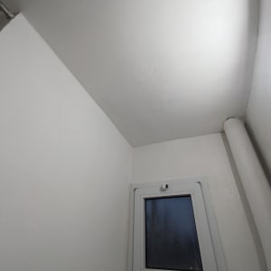 קיר ותקרה צבועים עם חלון קטן