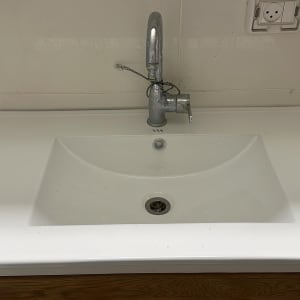 כיור עם ברז מותקן על קיר לבן