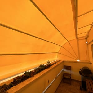 סוכך כתום מתוח מעל מרפסת קטנה