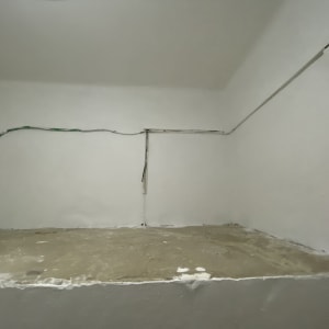 קיר צבוע בלבן עם חוטי חשמל חשופים