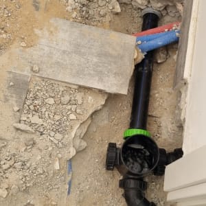 צינור פלסטיק שחור עם מחברים ירוקים באדמה