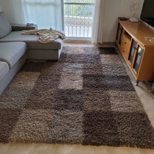 שטיח צבעוני על רצפה ליד ספה אפורה