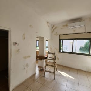 סולם בחדר עם קירות מוכנים לצביעה