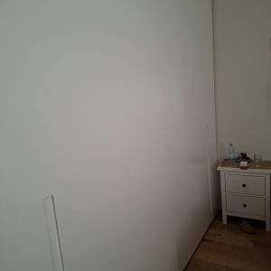 ארון בגדים לבן ליד שידה עם חפצים