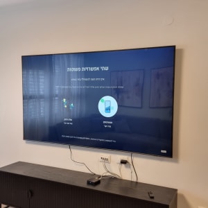 טלוויזיה תלויה על הקיר עם כבלים מחוברים