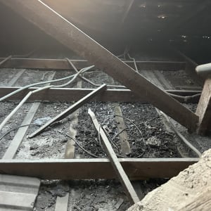 תמונה של גג עם קורות עץ וחוטים חשמליים