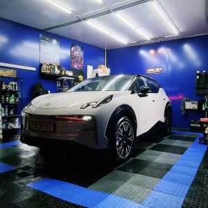 רכב לבן בחדר דיטיילינג עם ציוד ניקוי