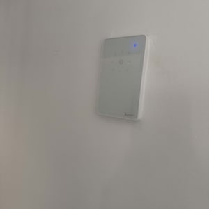 מתג חכם על קיר לבן עם נורית כחולה דולקת