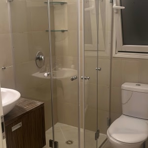 מקלחון זכוכית עם דלתות ומדפים בפנים