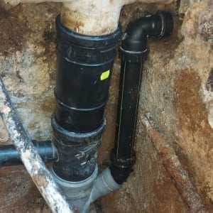 צינורות ביוב שחורים ולבנים מותקנים בקיר