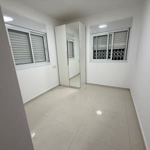 חדר ריק עם חלונות וארון מראה