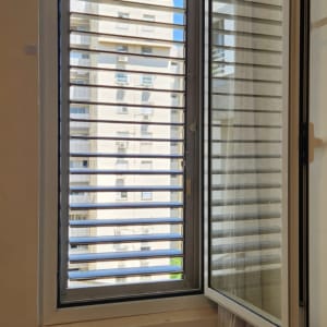 חלון עם תריסים פתוחים בבניין מגורים