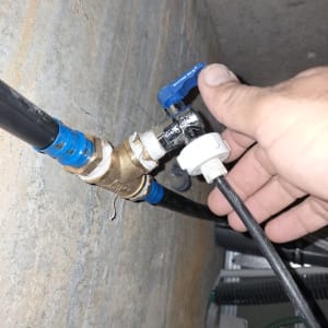 יד מחזיקה ברז מים כחול עם צינורות מחוברים