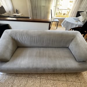 ספה אפורה בחדר עם כריות ושולחן