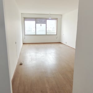 חדר עם רצפת עץ וקירות צבועים בלבן