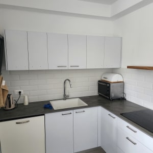 מטבח מודרני עם ארונות לבנים וכיור נירוסטה