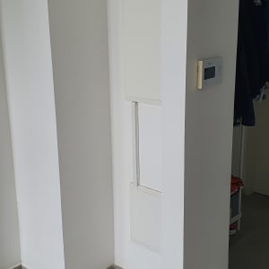 קיר לבן עם לוח חשמל ותרמוסטט