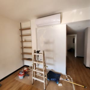 סולם, דלי צבע ומברשת בחדר צבוע חלקית