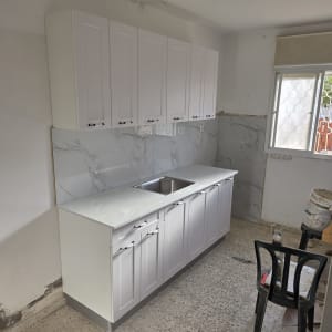 מטבח חדש עם ארונות לבנים וכיור נירוסטה