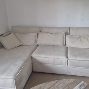 ספה בהירה עם כריות בחדר מגורים