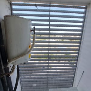 רשת מתכת מותקנת על חלון למניעת כניסת יונים