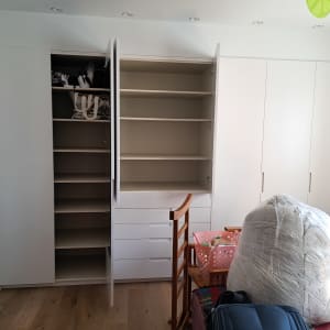 ארון פתוח עם מדפים ריקים ותיקים מאוחסנים