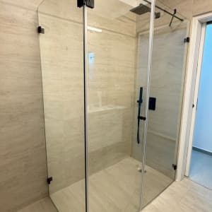 מקלחון זכוכית פינתי עם פרזול שחור בחדר רחצה מודרני