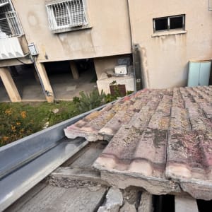תקריב של גג רעפים עם נזק ותיקונים