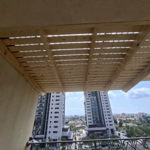 פרגולה מעץ במרפסת עם נוף לעיר