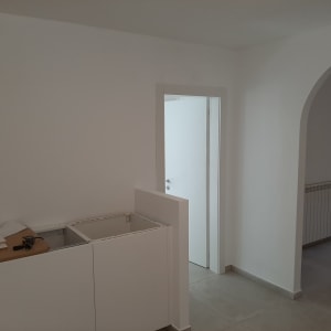 ארון מטבח לבן בבנייה עם כלים על השיש