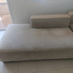 ספה בהירה ליד חלון עם אור שמש
