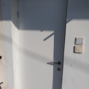 דלת לבנה עם ידית מתכת ומתג ליד