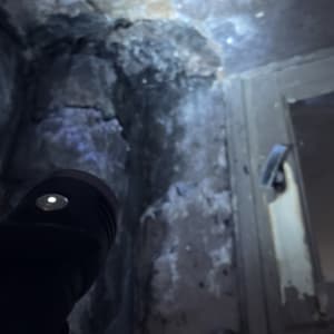 בדיקת נזילה וסימני רטיבות קשים על קיר פנימי בעזרת פנס