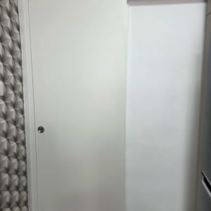 דלת הזזה לבנה על קיר עם טפט גיאומטרי