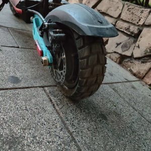 גלגל אחורי של קורקינט עם בלם דיסק על מדרכה