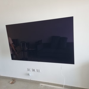 טלוויזיה מותקנת על קיר עם חוט חשמל מחובר