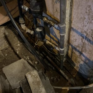 צינורות מים וברזים מותקנים על קיר בטון