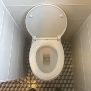 אסלה מותקנת על רצפה עם אריחים גיאומטריים