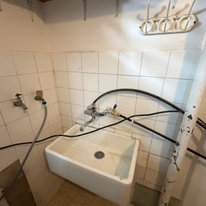כיור עם ברזים וצינורות בחדר קטן