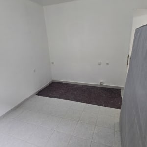 חדר ריק עם קירות לבנים ורצפת אריחים