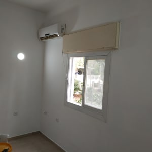 קיר צבוע בלבן עם חלון ומזגן