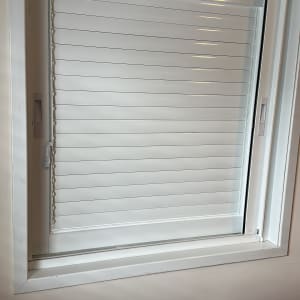 תריסים לבנים מותקנים בחלון קיר
