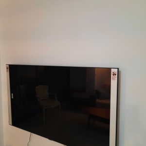 טלוויזיה תלויה על קיר עם כבלים חשמליים