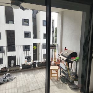 דלת זכוכית במרפסת עם נוף לבניין מגורים